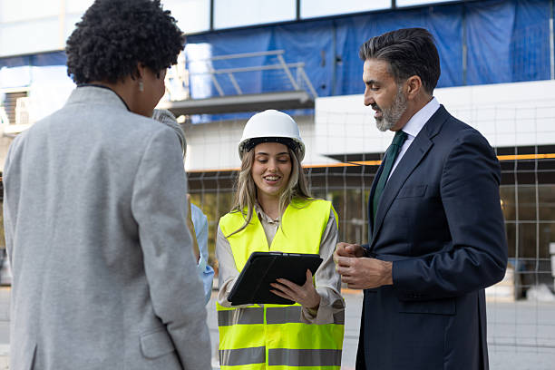 istock Architect showing tablet to businesspeople at construction site 2211746383