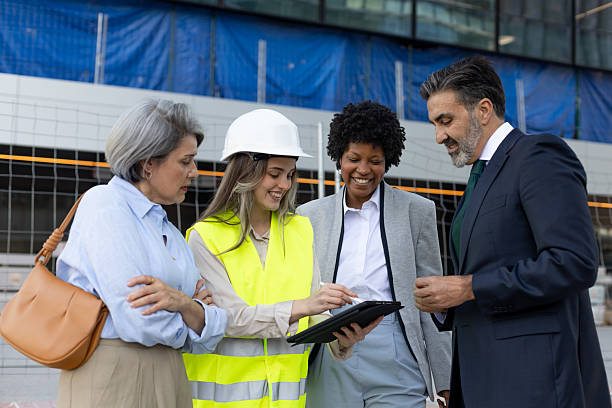 istock Engineers and investors discussing building project using tablet at construction site 2211746385