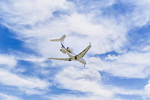 istock Private business plane flying under a blue sky with white clouds 2211747249