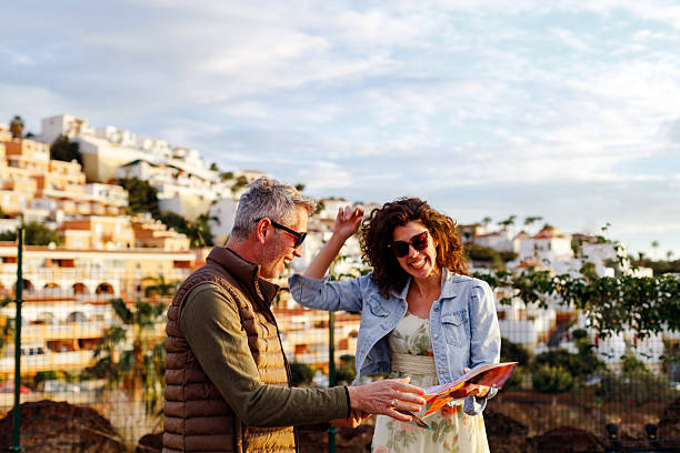 istock Happy tourist couple exploring Tenerife, holding a map in their hands 2211748263