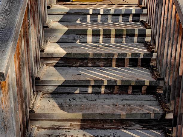 istock wooden stairs leading up with cast shadows creating interesting patterns in warm afternoon sunlight. 2211749839