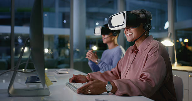 istock VR headset, futuristic and people with tech, colleagues and working late with computer and happiness. Night, coworkers and customer service with digital software, smile and communication with mic 2211750577