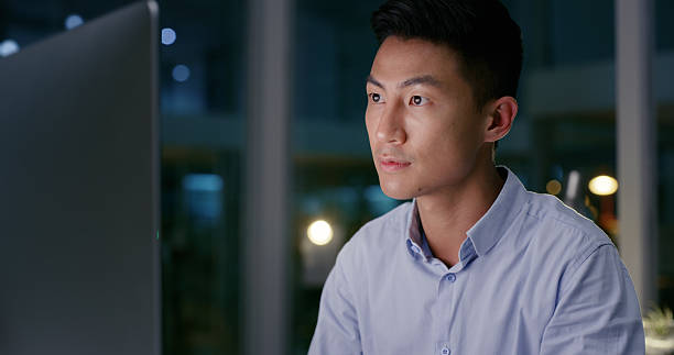 istock Business, night and man with computer in office for testing applications, late programming and coding deadline. Web developer, employee and reading online software for system update and UI design 2211750658