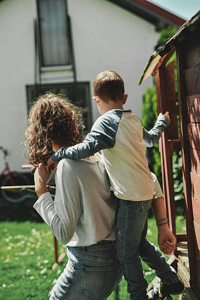 istock Little Boy Climbing on Sister's Back Enjoying Play Time With Her 2211761022