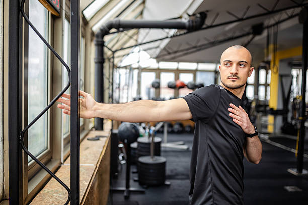 istock Young man performing stretching exercises in a gym environment to enhance flexibility and mobility 2211761293