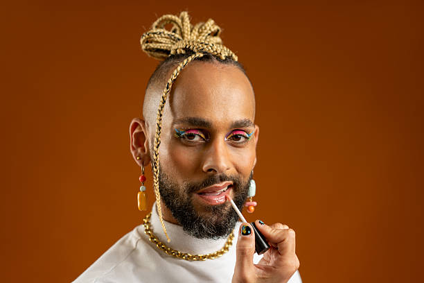 istock African american gay applying make up isolated on brown background 2211762209