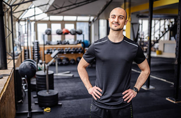 istock Young man showcases confidence and dedication while exercising in a modern gym environment with various workout equipment 2211764792