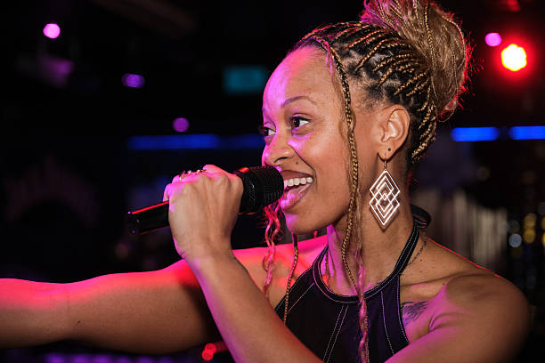 istock Young woman singing with microphone in nightclub 2211766949