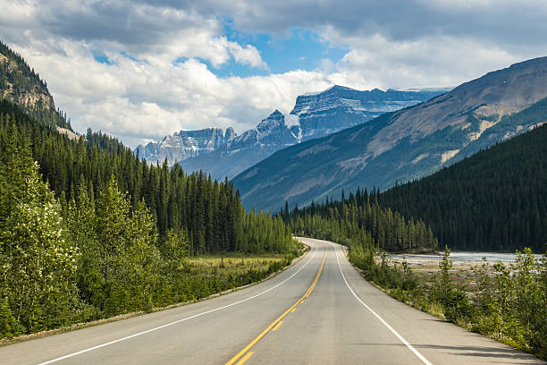 istock Scenic winding road through mountains and forests on a clear day with soft clouds 2211770708