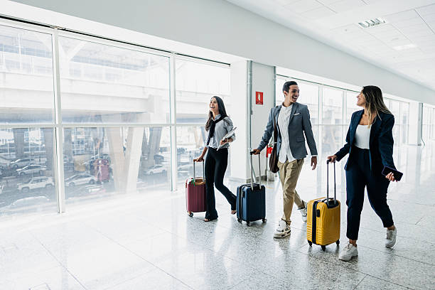 istock Coworkers talking while walking at the airport 2211774523