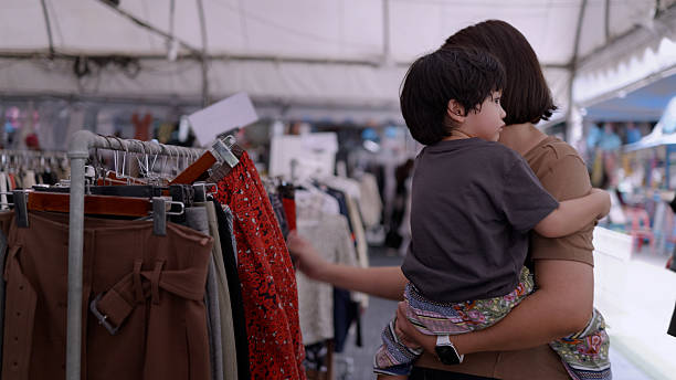 Asian mother and son shopping for cheap second-hand clothes. Zero waste.