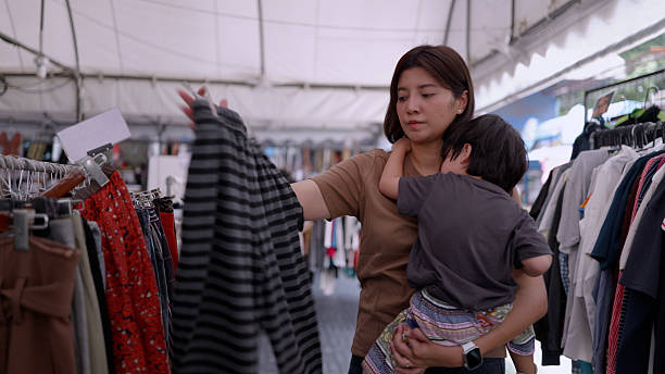 istock Asian mother and son shopping for cheap second-hand clothes. 2211777845