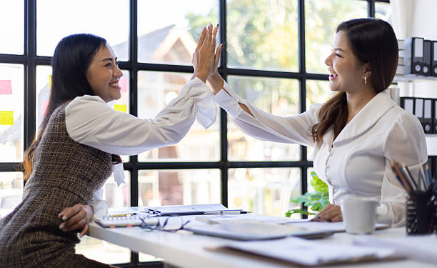 istock Female co-workers express happiness when they succeed at work. 2211778213