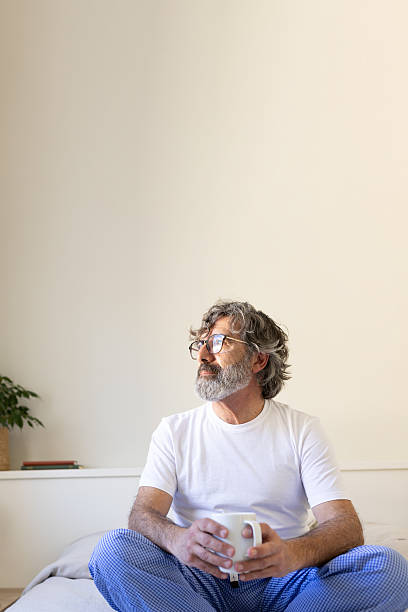istock Thoughtful senior man enjoying morning coffee in bed 2211778790