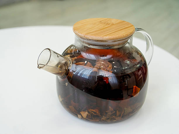 istock Glass teapot with flower tea stands on white table in office 2211780243
