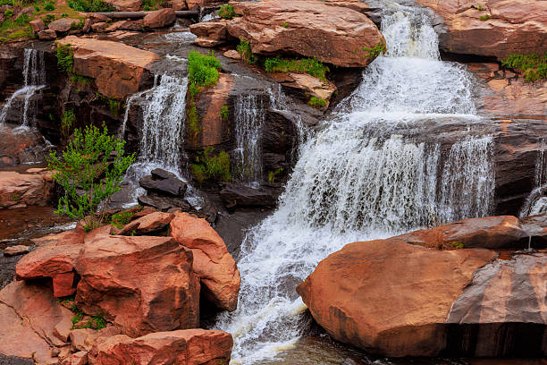 istock Water cascades down rocky surfaces in a serene natural setting during the daytime at a tranquil location 2211781350