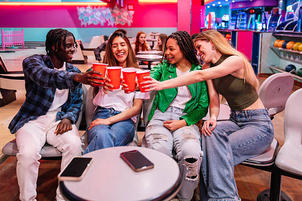 istock Friends toasting drinks and enjoying bowling alley fun 2211782414
