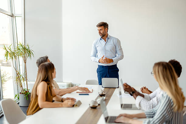 istock Confident Businessman Leading Team Meeting in Modern Office 2211785226