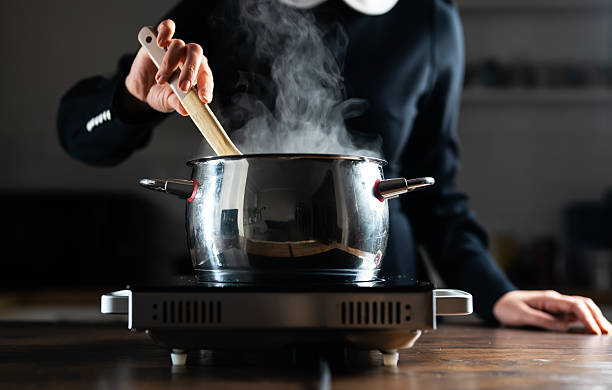istock Female chef cooking with steam rising from pot. 2211787679