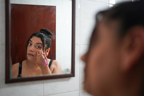 istock Woman applying makeup in the bathroom mirror 2211793656