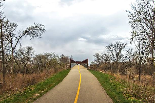 The North Branch Trail climbs to a distant bridge beneath a cloudy sky on a Spring day near Chicago, Illinois.