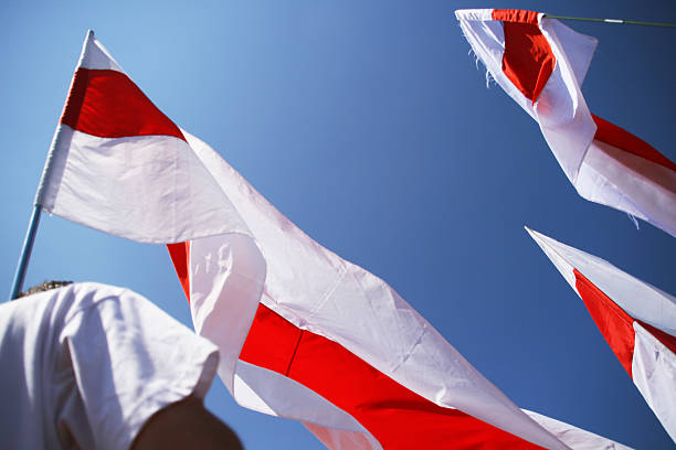 White Red White Flags Waving Against Blue Sky