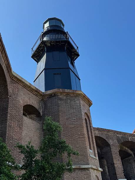 istock Black Lighthouse sits atop brick wall turret 2211798423