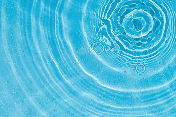 istock drops on water with circles on a blue background 2211799745