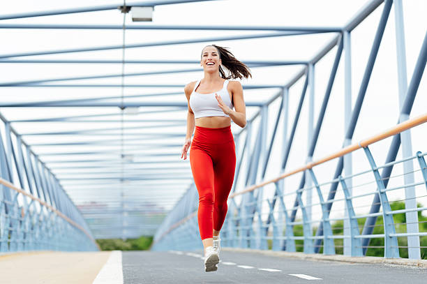 istock Fit woman jogging on a modern bridge during a sunny day 2211799839