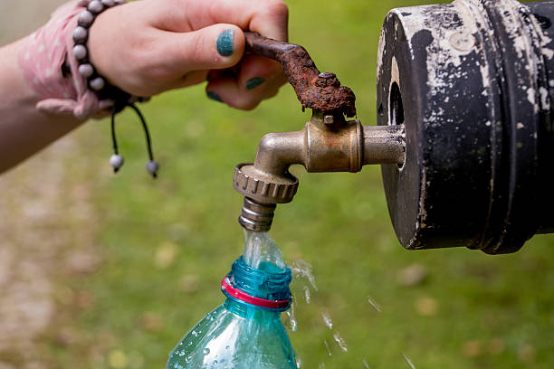 istock female hands filling water bottle from tap 2211808090