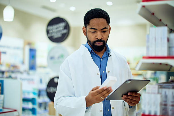 istock Pharmacist Reviewing Medication in Modern Pharmacy with Digital Tablet 2211810446