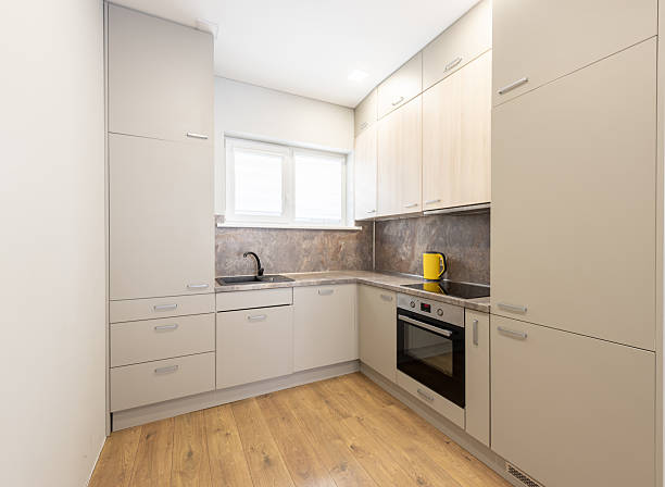 istock Modern Compact Kitchen with Beige Cabinets and Wooden Flooring 2211826072