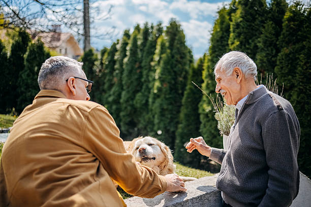 istock Enjoying talking with older people in home back yard while having dog around 2211826158