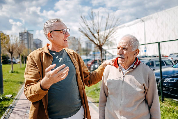 istock Enjoying talking with older people while walking in public park on sunny day 2211826178