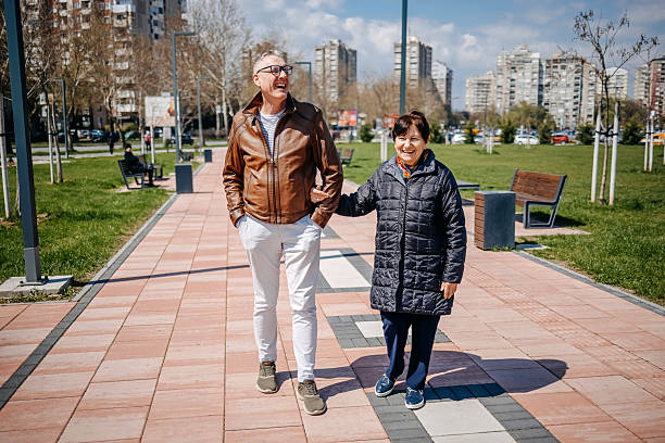 istock Enjoying talking with older people while walking in public park on sunny day 2211826375