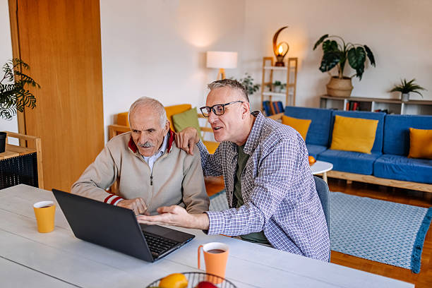 istock Enjoying talking with older people at home while showing how to use laptop 2211826396