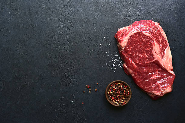 istock Raw organic marbled beef steak with ingredients for cooking . Top view with copy space. 2211826819