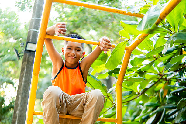 Smiling child having fun on playground equipment in a park, promoting physical activity, mental well-being, and outdoor play