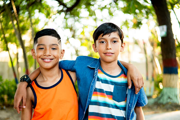 istock Two happy elementary age boys hugging in the park 2211829933