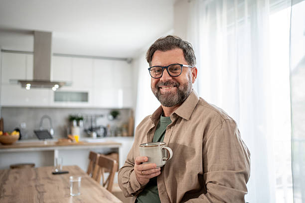 istock Smiling mature man enjoying morning coffee in kitchen 2211833047