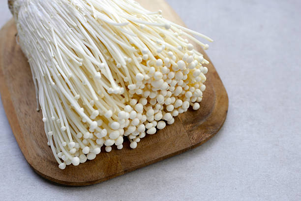 istock Fresh Enoki mushrooms on white background 2211833569