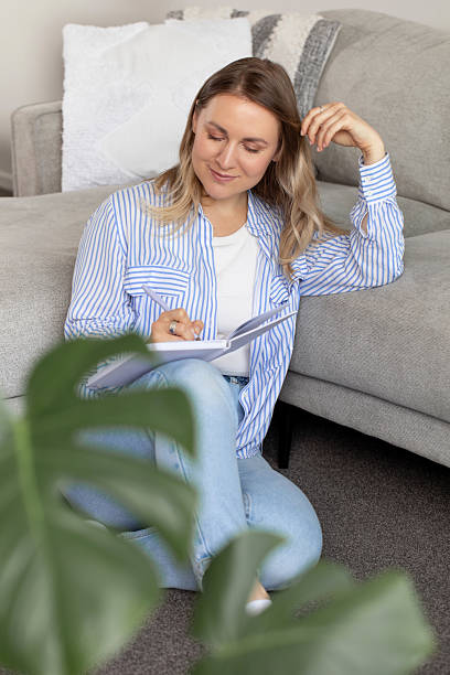 istock Woman writes interesting thoughts in diary sitting on floor 2211839207