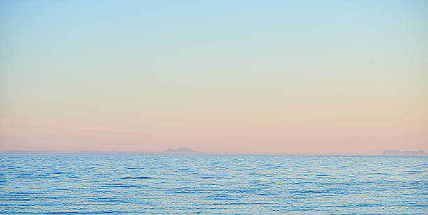 istock Serene ocean surface under a vivid pastel sky at dusk highlighting tranquility 2211844291
