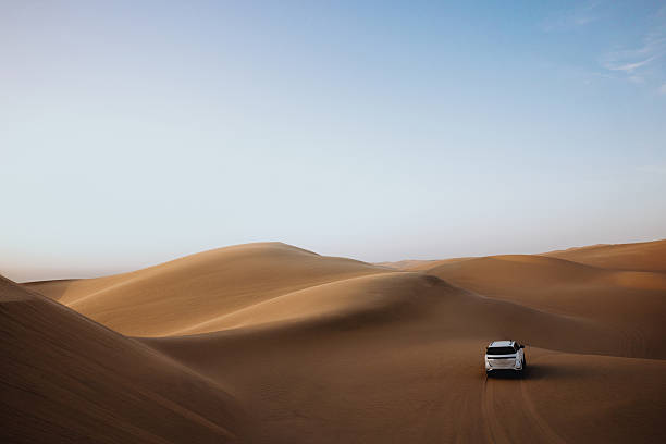 istock White suv driving on sand dunes in desert landscape 2211844432