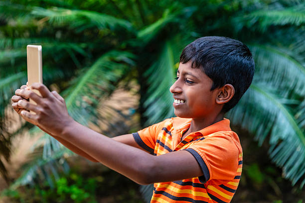 Sri Lankan teenager using digital tablet near Sigiriya, Sri Lanka (Ceylon).