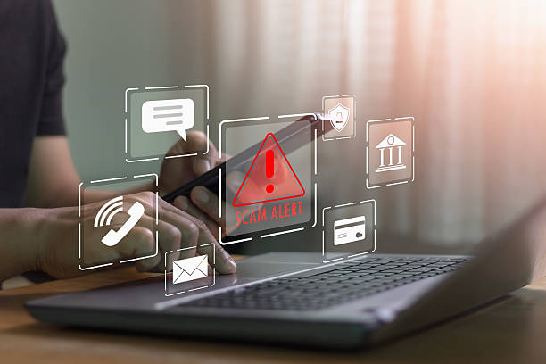 istock Cyber security concept. Scam alert warning. Businessman using laptop, warning sign for scam with icon representing online threat, phishing, and cybersecurity. Unknown person, suspicious scammer, fraud 2211844835