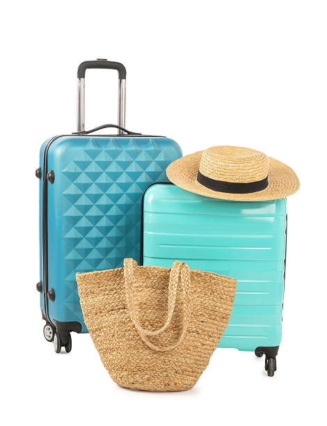 istock Light blue suitcases, bag and straw hat isolated on white 2211845696