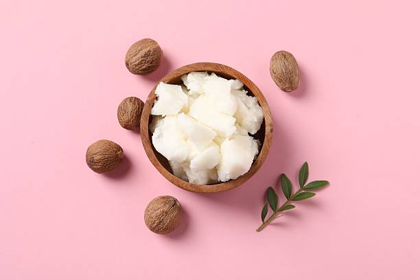 istock Natural shea butter and nuts on pink background, flat lay 2211846748