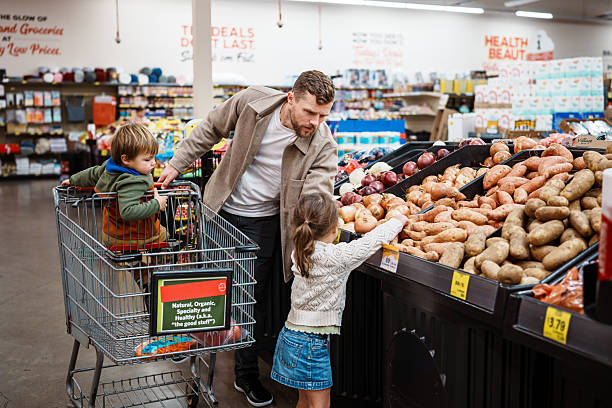 istock Dad grocery shopping with his kids 2211846958