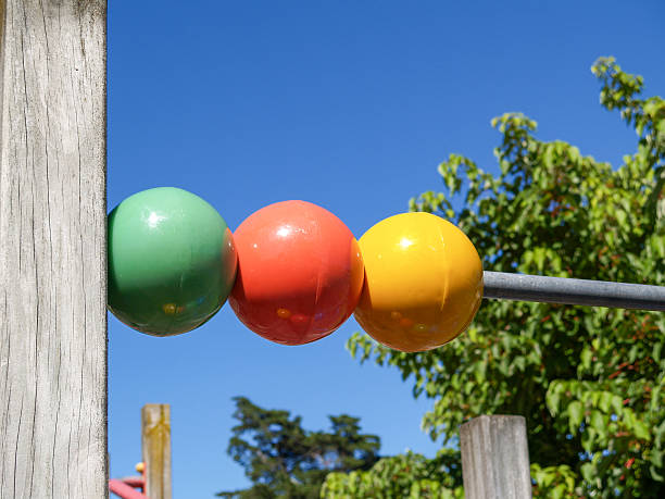 Multi-coloured playground spheres on rod for children to play.